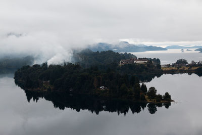 Scenic view of lake by buildings against sky