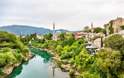 River amidst trees and buildings against sky