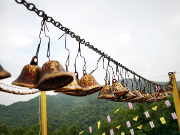 Close-up of rusty chain against sky