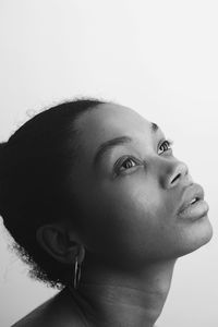 Close-up of young woman looking up over white background