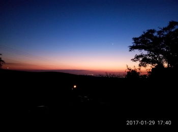 Silhouette trees against sky during sunset