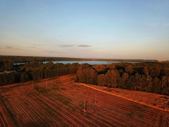 Scenic view of agricultural field against sky during sunset