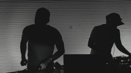 Rear view of silhouette people standing by window