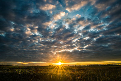 Scenic view of field against dramatic sky