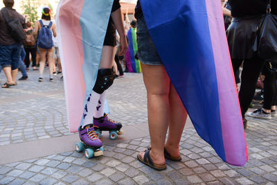 People wearing rainbow flag during parade in city