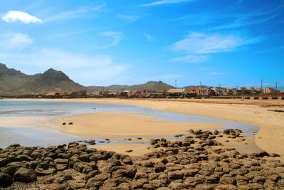 Scenic view of beach against blue sky