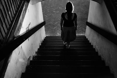 Rear view of woman walking on stairs