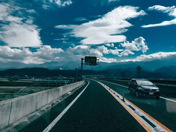 Empty road against cloudy sky