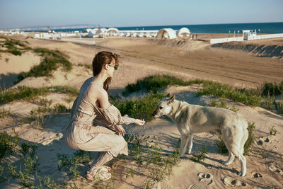 Rear view of woman with dog on beach