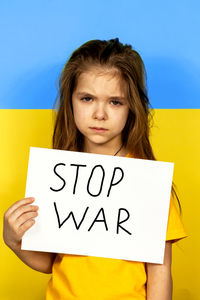 Portrait of young woman with text on blackboard