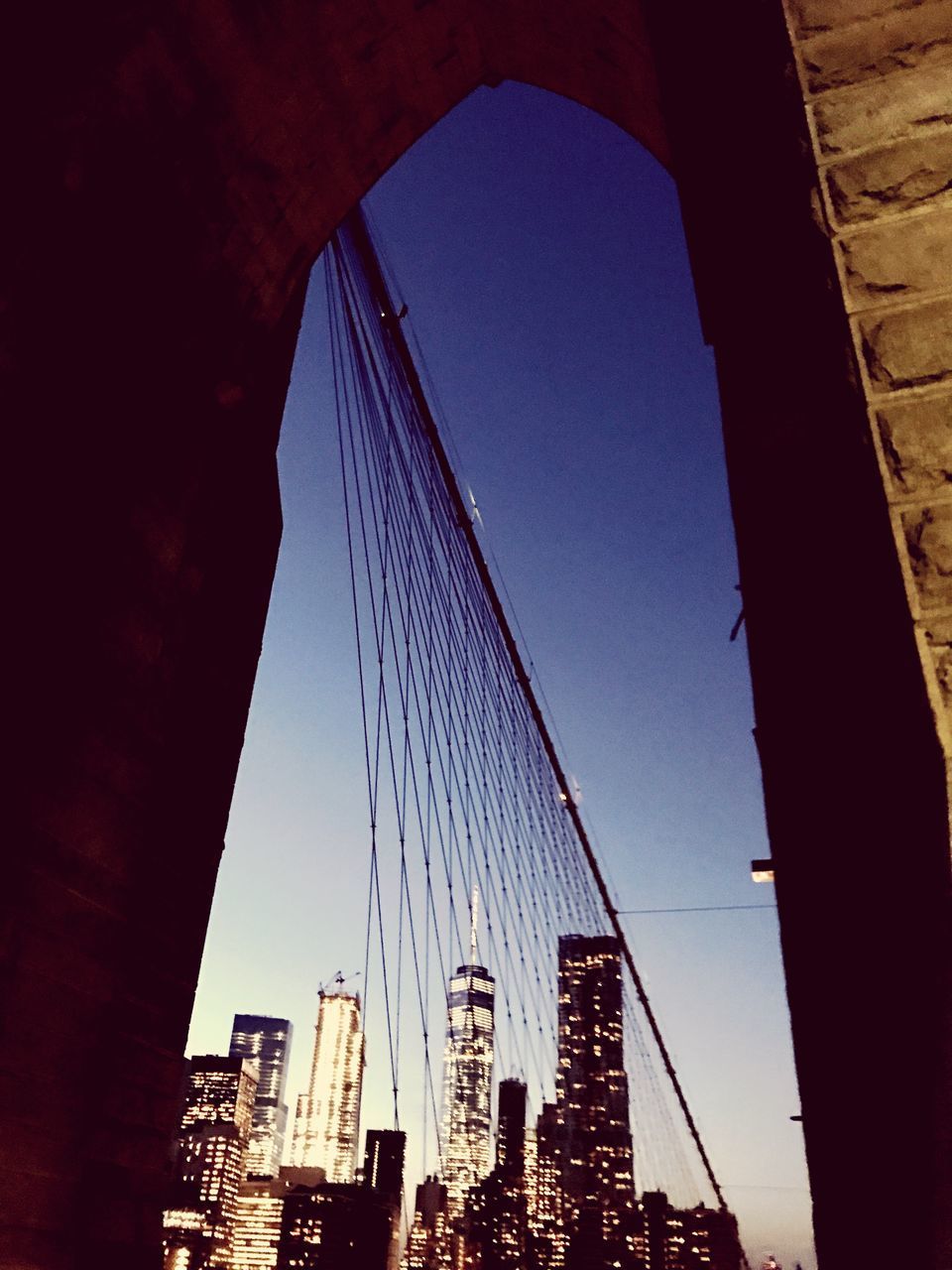 LOW ANGLE VIEW OF SUSPENSION BRIDGE IN CITY AGAINST SKY