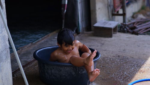 High angle view of shirtless boy in water