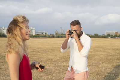 Man photographing young woman