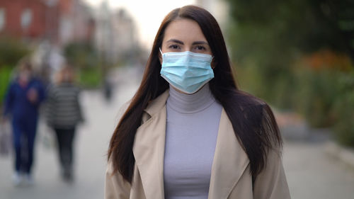 Portrait of young woman on street in city