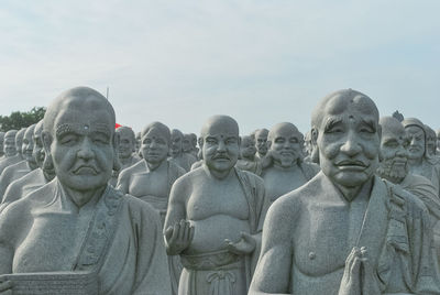 Close-up of statues against sky