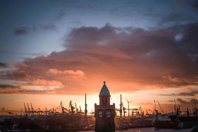 Clock tower against cloudy sky during sunset