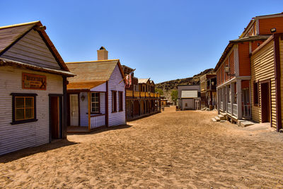 Houses amidst buildings against blue sky