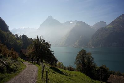 Scenic view of lake by mountains against sky