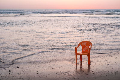 Lifeguard hut on beach against sky during sunset