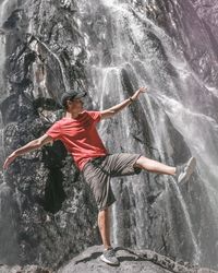 Man standing on rock by sea