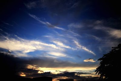 Low angle view of silhouette trees against sky