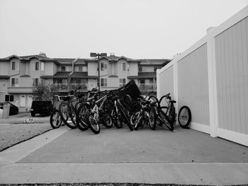 Bicycles parked on road by building against clear sky