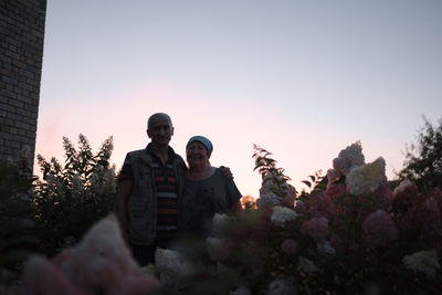 People on flowering plants against clear sky