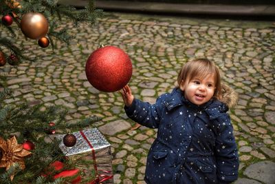 Sweet girl playing with christmas ornaments