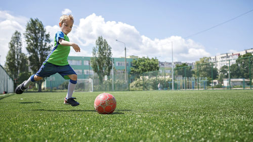 Boy playing with ball in park