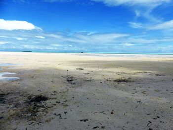 Scenic view of beach against blue sky