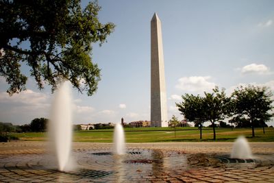 Fountain in city against sky