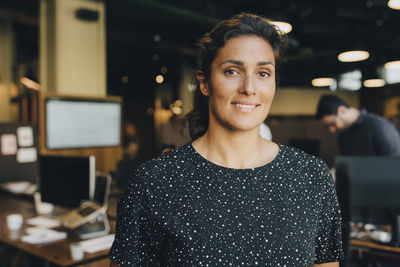 Portrait of confident businesswoman smiling in creative office