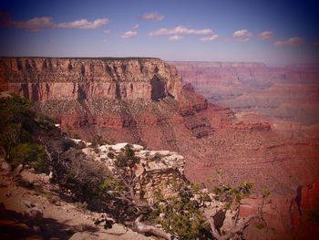 Rock formations on landscape against cloudy sky