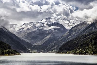 Scenic view of snowcapped mountains against cloudy sky