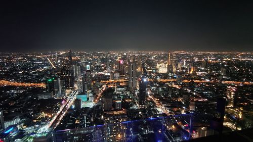 High angle view of illuminated cityscape against sky at night