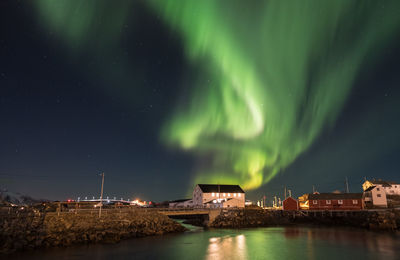 Aurora polaris over lake against sky at night