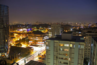 Illuminated buildings in city against sky at night