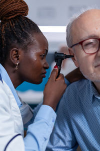 Doctor checking patient's ear at clinic