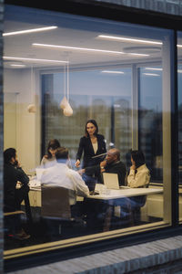 Mature businesswoman discussing with male and female colleagues at work place
