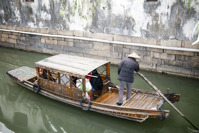 High angle view of man sailing boat in canal