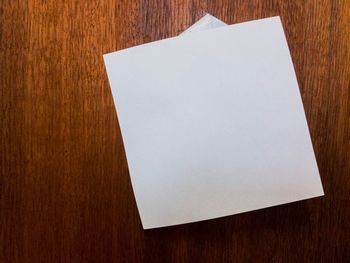 High angle view of white paper on wooden table