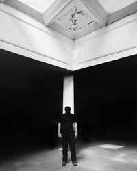 Rear view of woman standing in tunnel