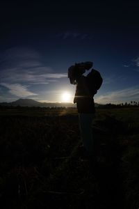 Man photographing on field during sunset