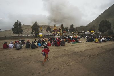 People on shore against sky