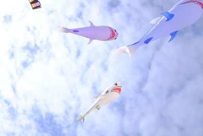 Low angle view of animal balloons flying against sky
