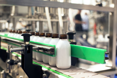 Close-up of bottles on conveyor belt in factory