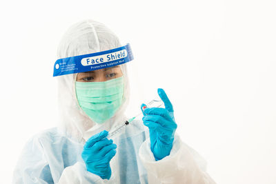 Doctor holding syringe against white background