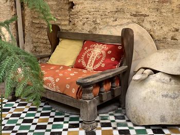 Old wooden chairs with colourful cushions against rock wall in fez morocco 