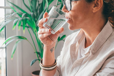 Side view of young woman drinking water