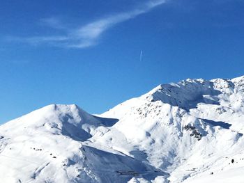 Scenic view of snowcapped mountains against blue sky